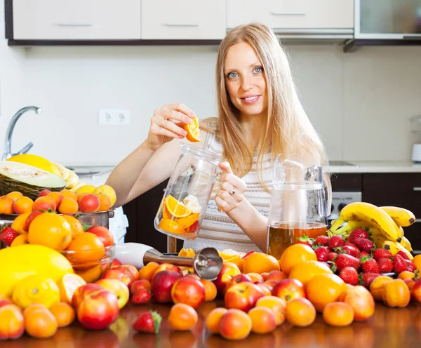 Smiling woman making fruits beverages — Stock Photo, Image