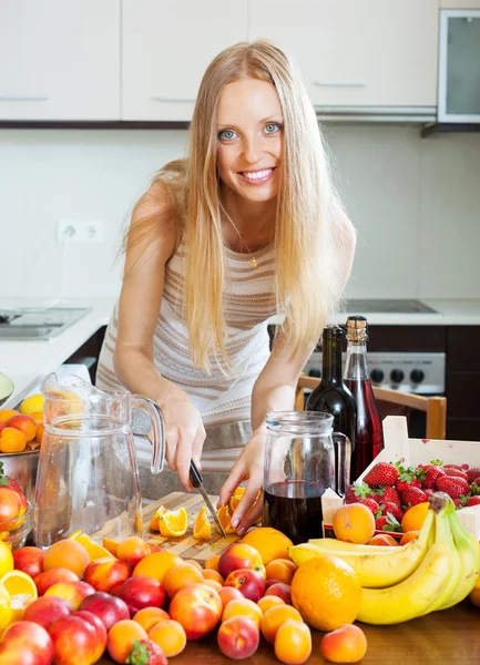 Alegre ama de casa haciendo cóctel con frutas —  Fotos de Stock