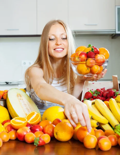 Blonde long-haired woman taking fruits — Stock Photo, Image