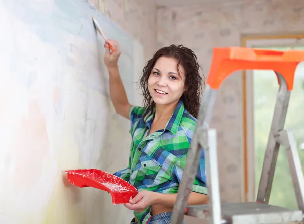 Mujer pinta la pared en casa — Foto de Stock