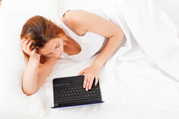 Ung kvinna vaknade med laptop — Stockfoto