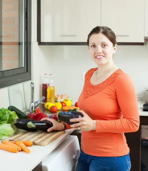 Positieve huisvrouw koken aubergines in huis — Stockfoto