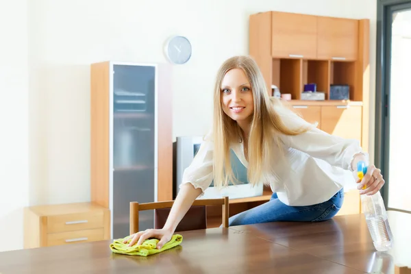 Kvinna rengöring bord med trasa och rengöringsmedel — Stockfoto