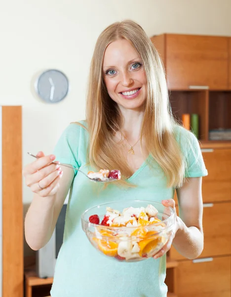 Mulher loira feliz comendo salada de frutas — Fotografia de Stock