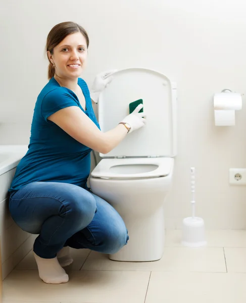 Femme souriante nettoyage siège de toilette — Photo