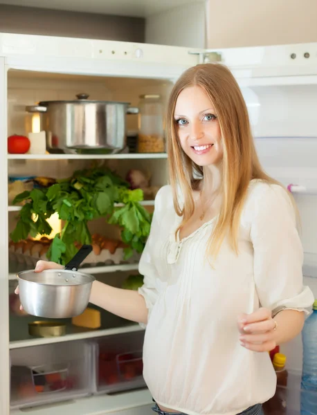 Positive Frau stellt Pfanne in Kühlschrank — Stockfoto