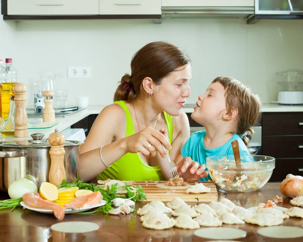 Mujer con chica cocinar albóndigas de pescado juntos en casa cocina — Foto de Stock