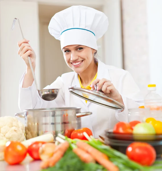 Happy young cook tests vegetarian food — Stock Photo, Image