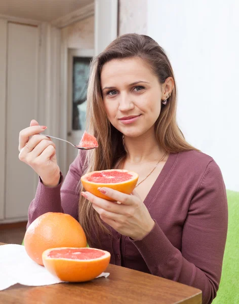 Långhåriga flicka äter grapefrukt — Stockfoto