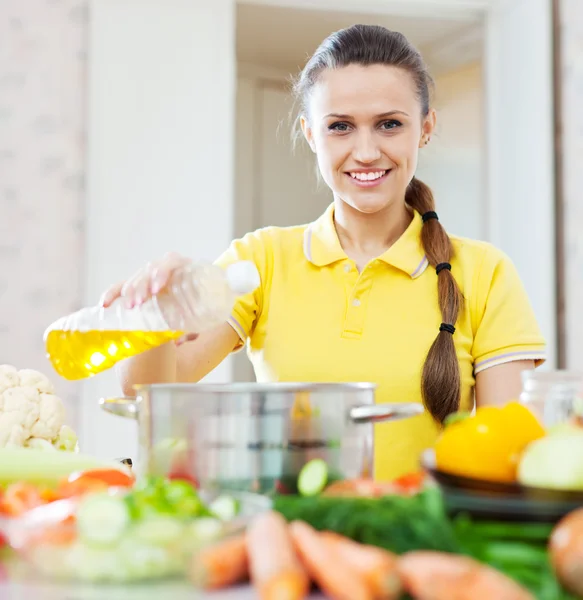 Donna versando olio dalla bottiglia — Foto Stock