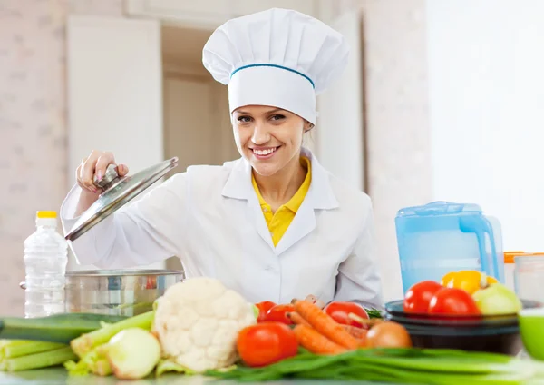 Готуйте в уніформі з овочами на кухні — стокове фото