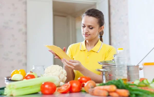 Schöne Frau hält ungekochte Nudeln — Stockfoto