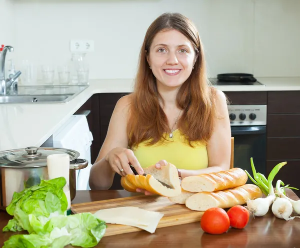 Mujer cocinando sándwiches con baguette — Foto de Stock