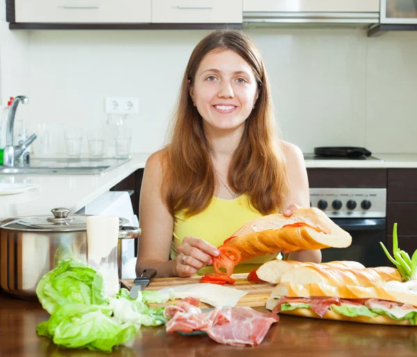 Mujer cocinando sándwiches con tomate y hamon —  Fotos de Stock