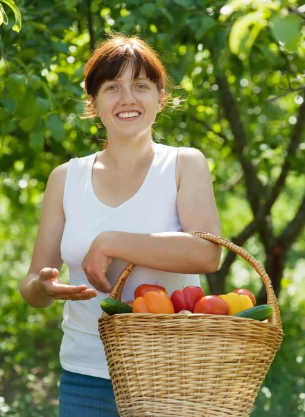 Счастливая женщина с овощами в саду — стоковое фото