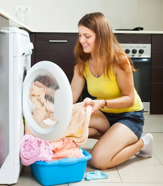 Woman putting clothes in to washing machine — Stock Photo, Image