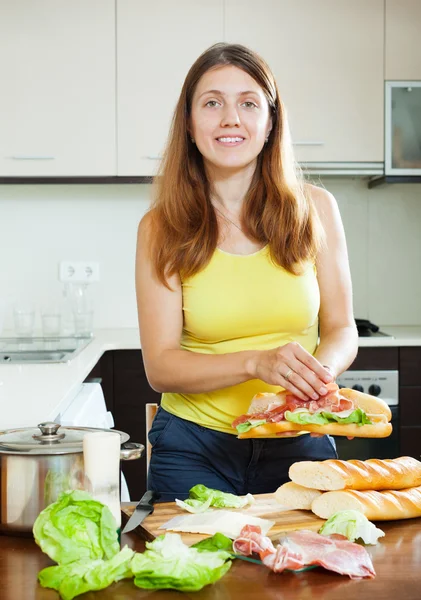Mujer feliz cocinando sándwiches españoles — Foto de Stock
