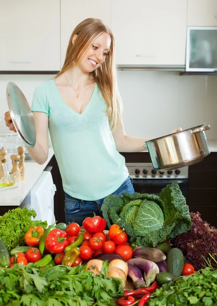 Happy woman cooking with pan and vegetables — Stock Photo, Image