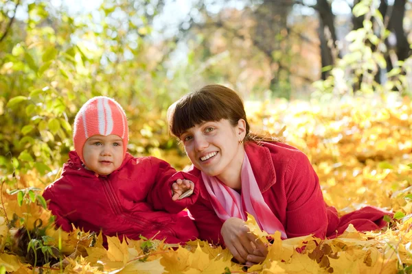 Mor och barn på lönn löv — Stockfoto