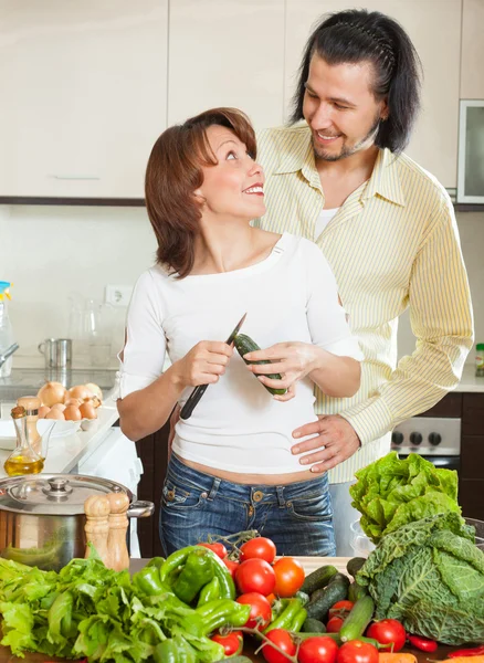 Un hombre y una mujer con verduras en la cocina — Foto de Stock