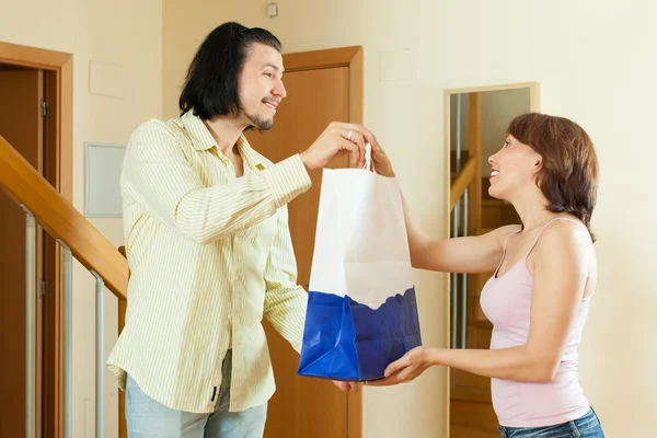 Homem veio a uma boa mulher com um presente em casa — Fotografia de Stock