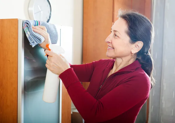 Mature woman cleaning furniture — Stock Photo, Image