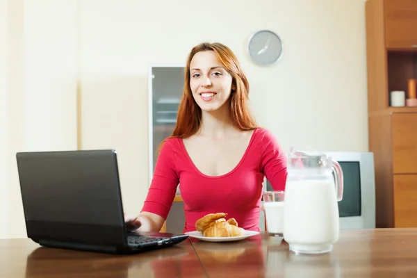 Frau benutzt Laptop beim Frühstück — Stockfoto