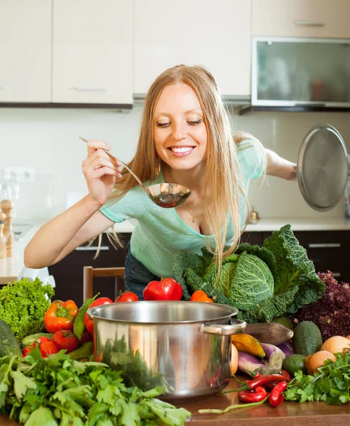 Woman cooking with ladle from vegetables — Stock Photo, Image