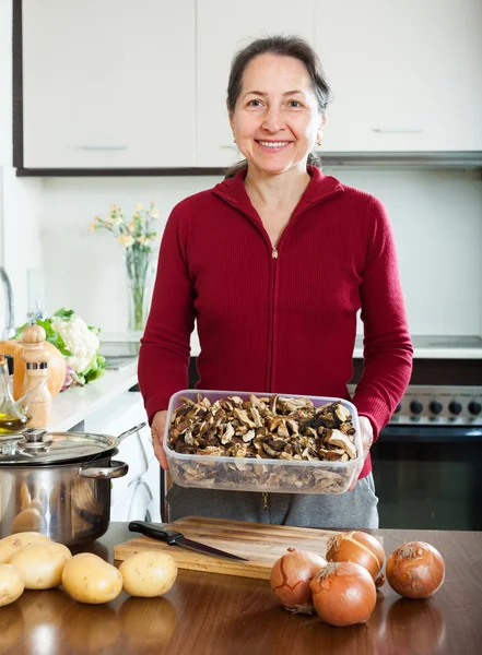 Mature housewife holding dried mushrooms — Stock Photo, Image