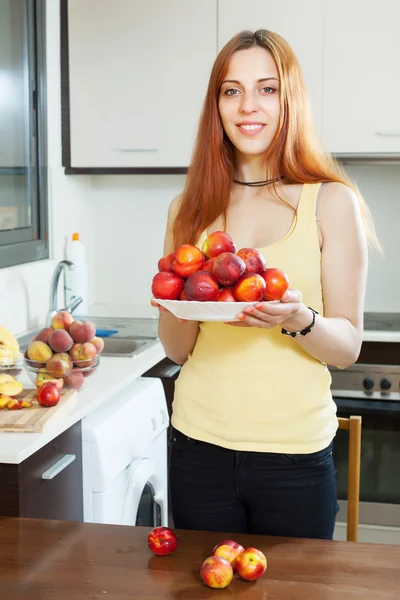 Pretty woman with nectarines — Stock Photo, Image