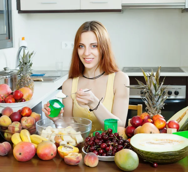 Vrouw maken fruitsalade met room — Stockfoto