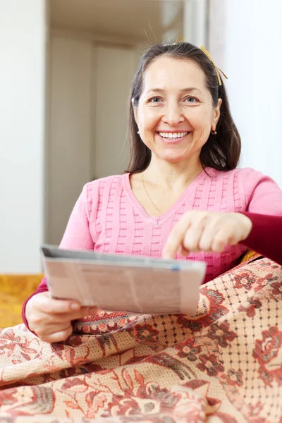 Mujer madura señalando al periódico — Foto de Stock