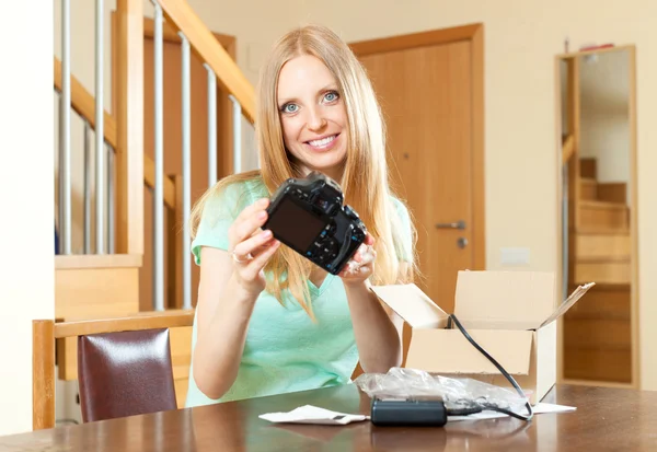 Mulher feliz desempacotar nova câmera digital em casa — Fotografia de Stock