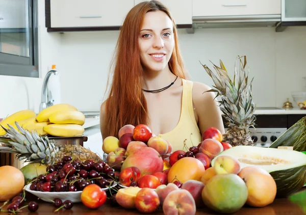 Позитивна жінка з купою стиглих фруктів — стокове фото