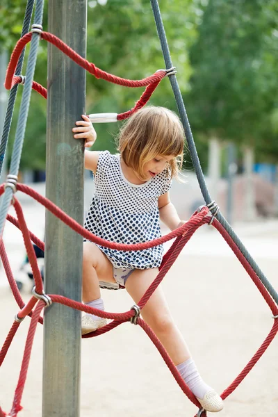 Meisje in jurk aan touwen klimmen — Stockfoto