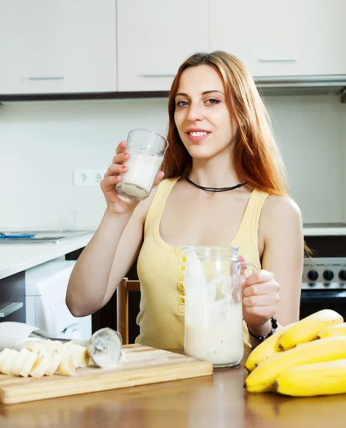 Ragazza in giallo bere frullato di latte con banane — Foto Stock