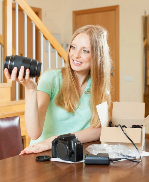 Giovane ragazza disimballaggio nuova fotocamera digitale in casa interna — Foto Stock