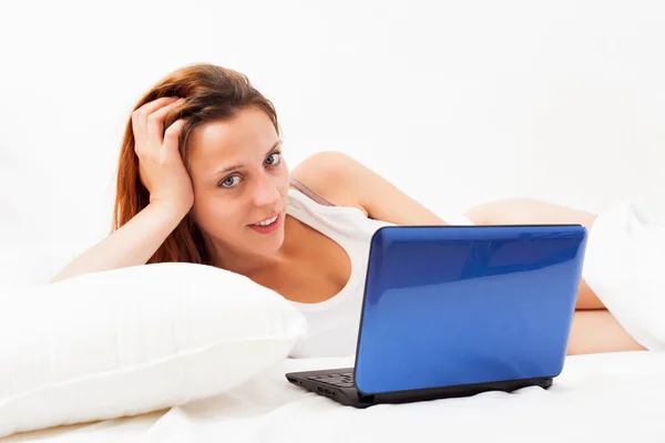 Frau mit Laptop auf weißem Laken — Stockfoto