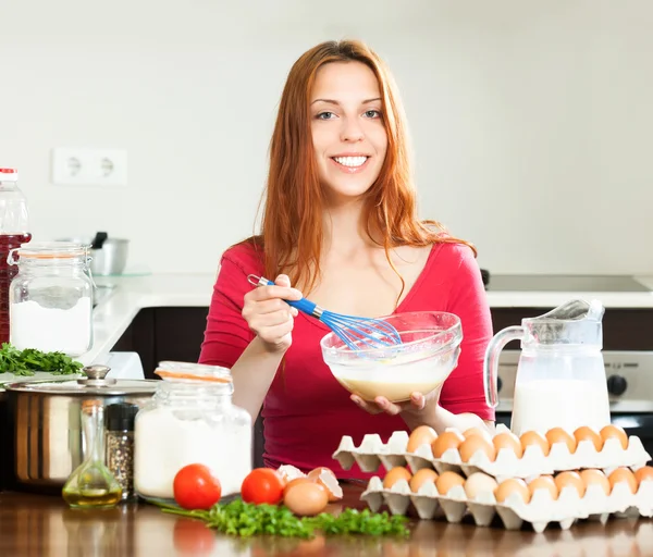 Gülümseyen kadın hamur veya omlet yapmak — Stok fotoğraf