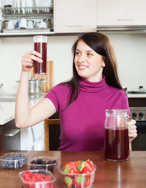 Счастливая женщина делает свежие напитки с ягодами — стоковое фото