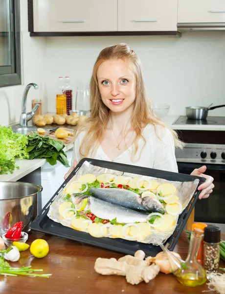 Dona de casa comum cozinhar peixe e batatas — Fotografia de Stock