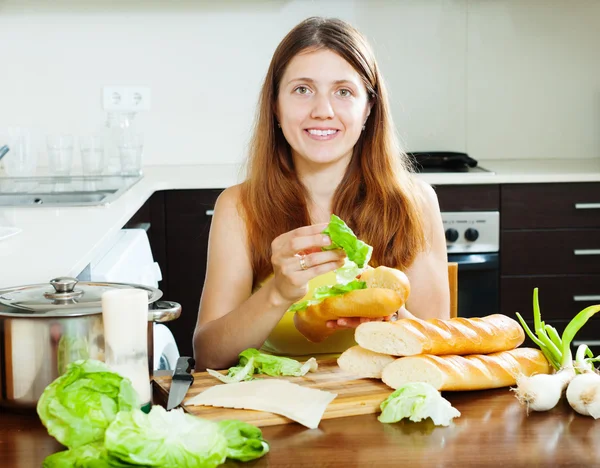 Kvinnan matlagning mackor med ost och grönsaker — Stockfoto