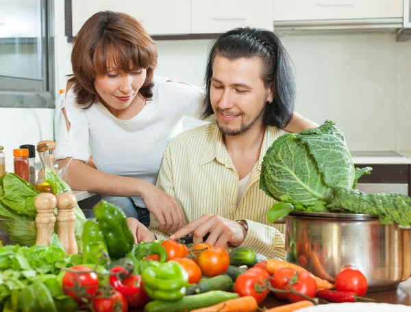 Vriendelijke getrouwd koppel voorbereiden plantaardige salade — Stockfoto