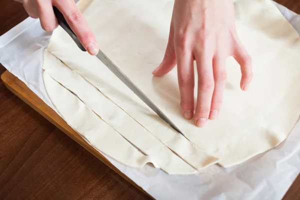 Hands cutting store-bought dough — Stock Photo, Image