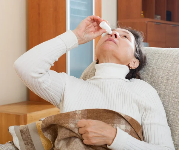 Mujer goteando gotas nasales — Foto de Stock