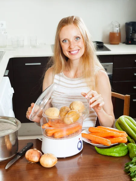 Hemmafru matlagning grönsaker med ångbåt — Stockfoto