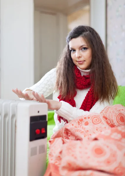 Girl warm hands near radiator — Stock Photo, Image