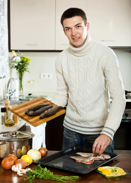 Guy cooking fish with lemon — Stock Photo, Image