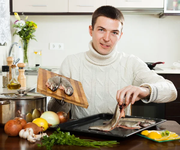 Chico cocinar trucha pescado — Foto de Stock
