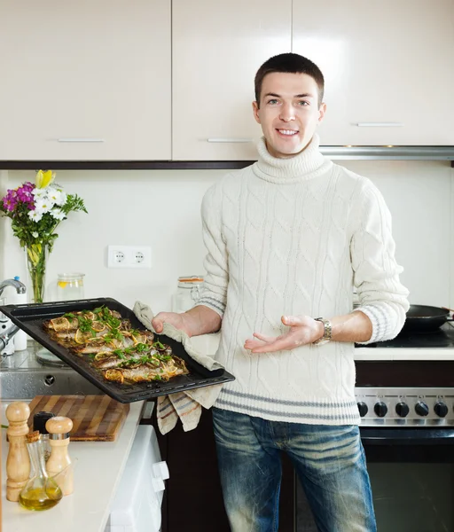 Guy with cooked fish on frying pan — Stock Photo, Image